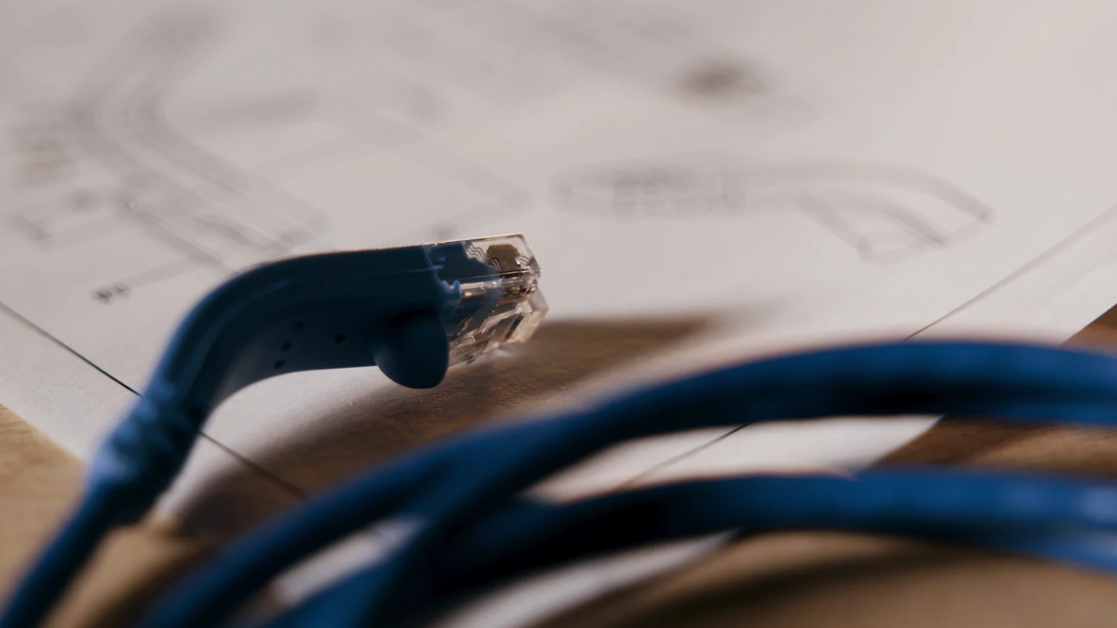 A blue cable and connector laid across an engineering drawing in Shaxon’s Concept to Reality film